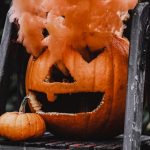 Creepy jack-o'-lantern emitting orange smoke, perfect for a Halloween vibe.